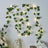 Artificial ivy garland with warm white fairy lights on a wall.