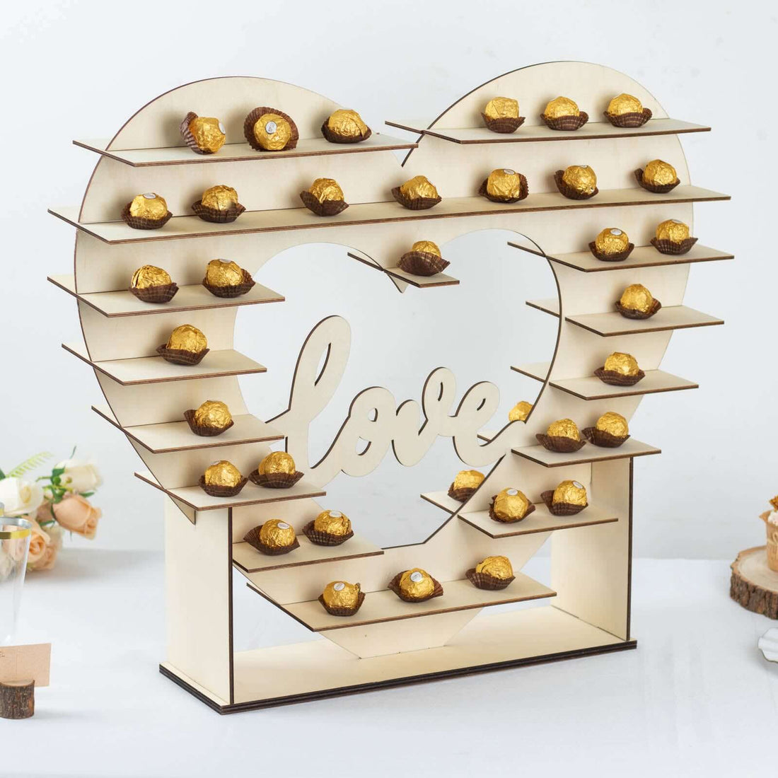 Heart-shaped dessert display stand with gold treats for weddings or events.