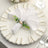 Elegant white napkin with greenery on decorative plate for table setting.