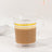 Clear coffee mug with yellow stripes filled with coffee.