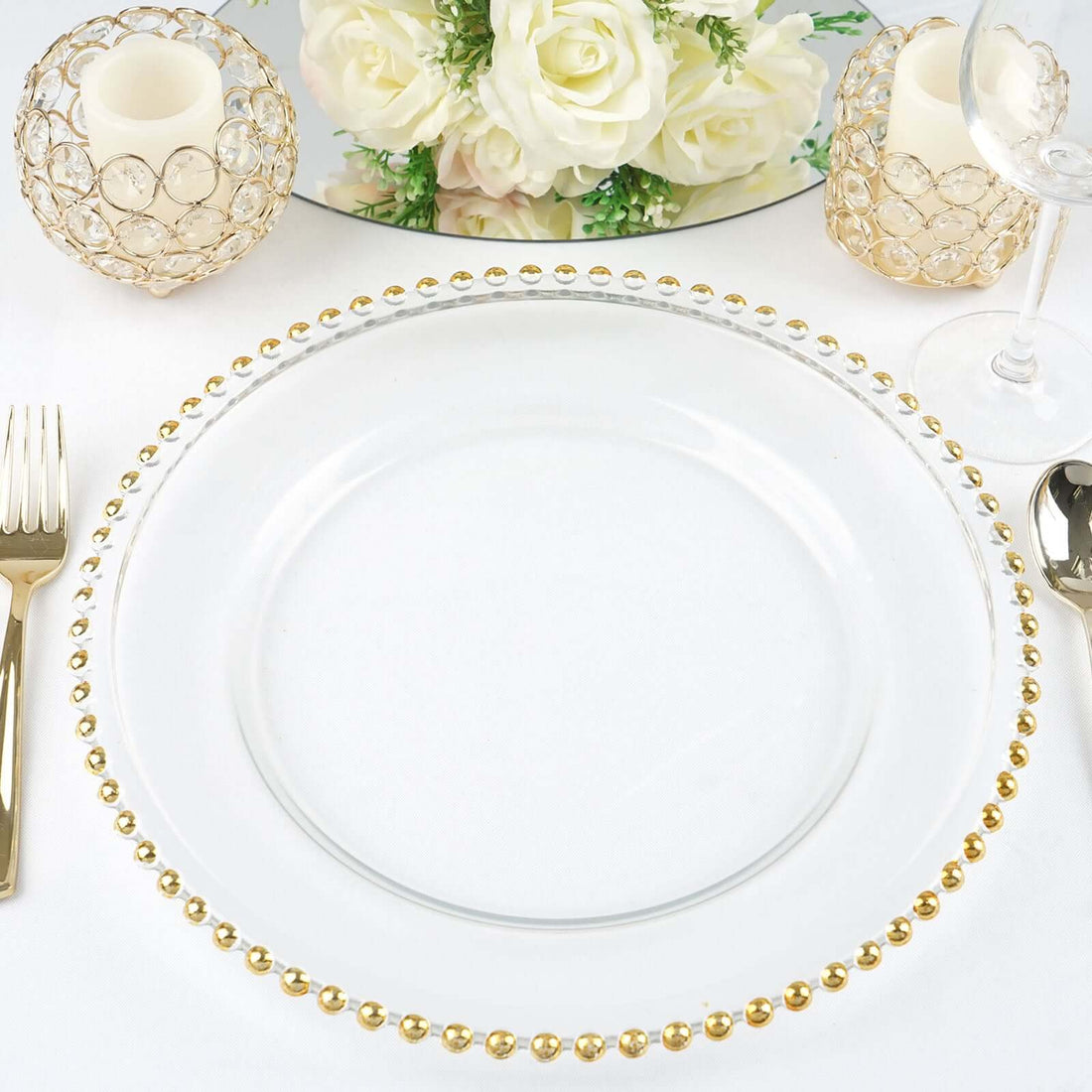Elegant clear plate with gold beaded rim, styled with candles and flowers.
