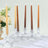 Elegant tapered candles in crystal holders with floral arrangement.
