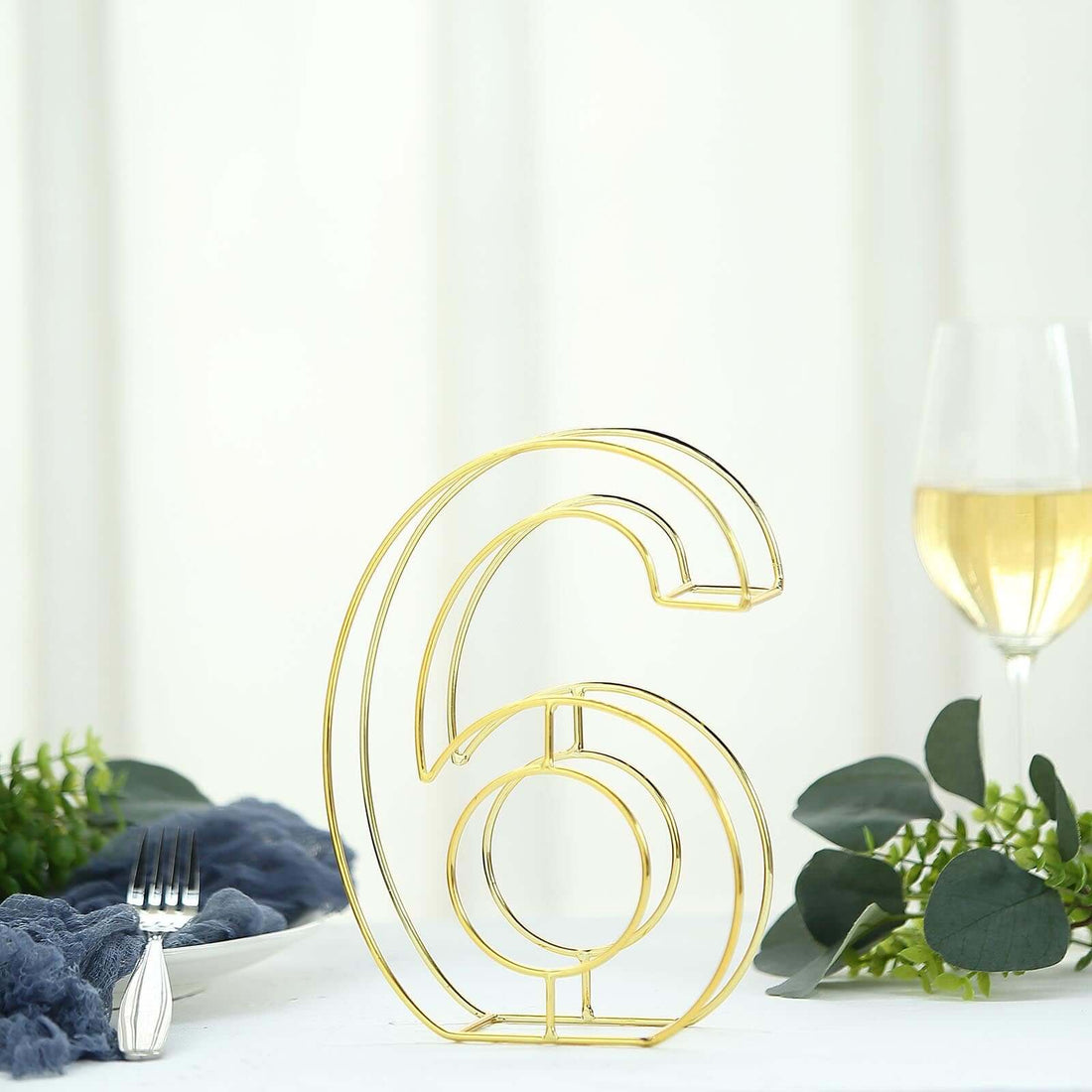 Gold table number 6 holder in a modern design for events and weddings.