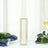 Gold geometric vase on a dining table with greenery and a wine glass.