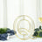 Gold abstract sculpture on a table with greenery and tableware.