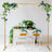 Elegant wedding arch with floral decor and clear chairs at a styled table setting.