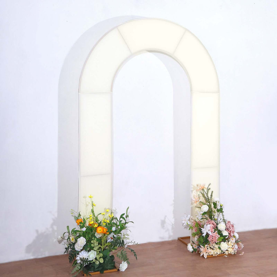 White floral arch with vibrant flowers at the base