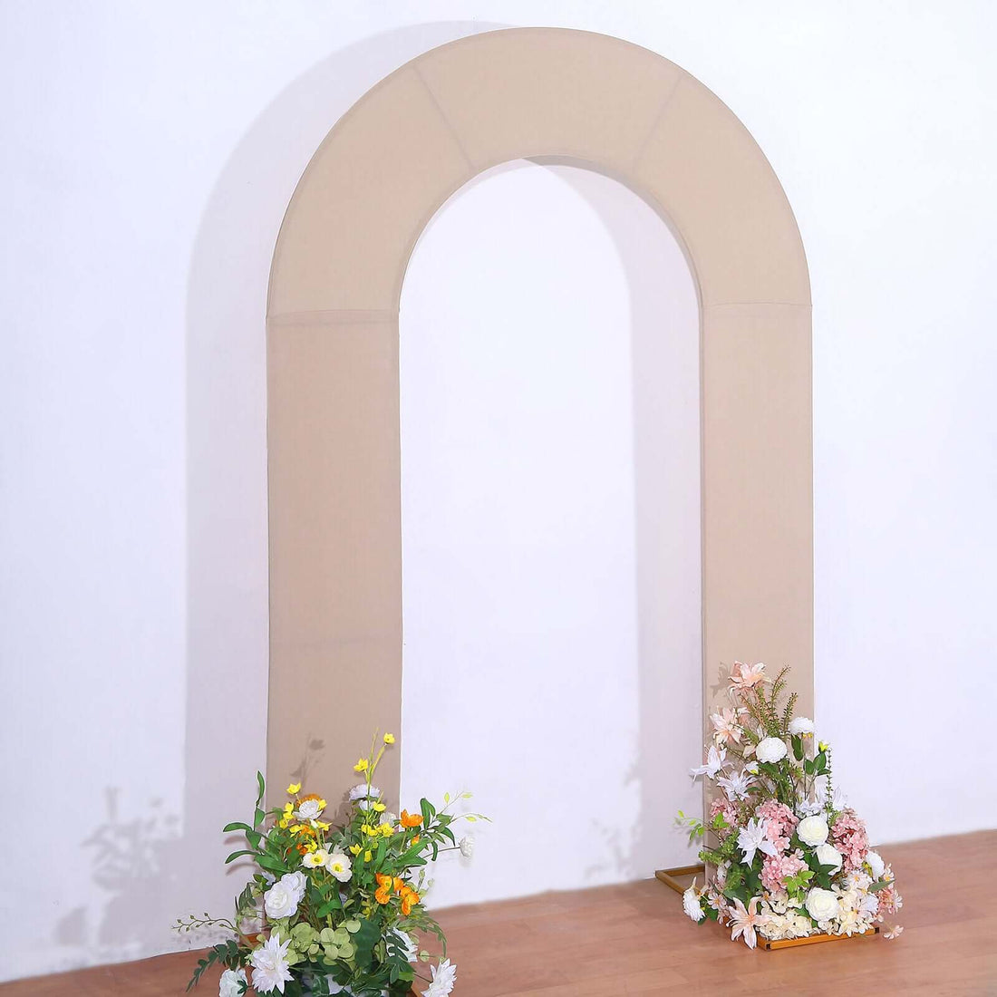 Beige arch backdrop with floral arrangements for events or photography.