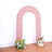 Pink glitter arch with floral arrangements at the base.