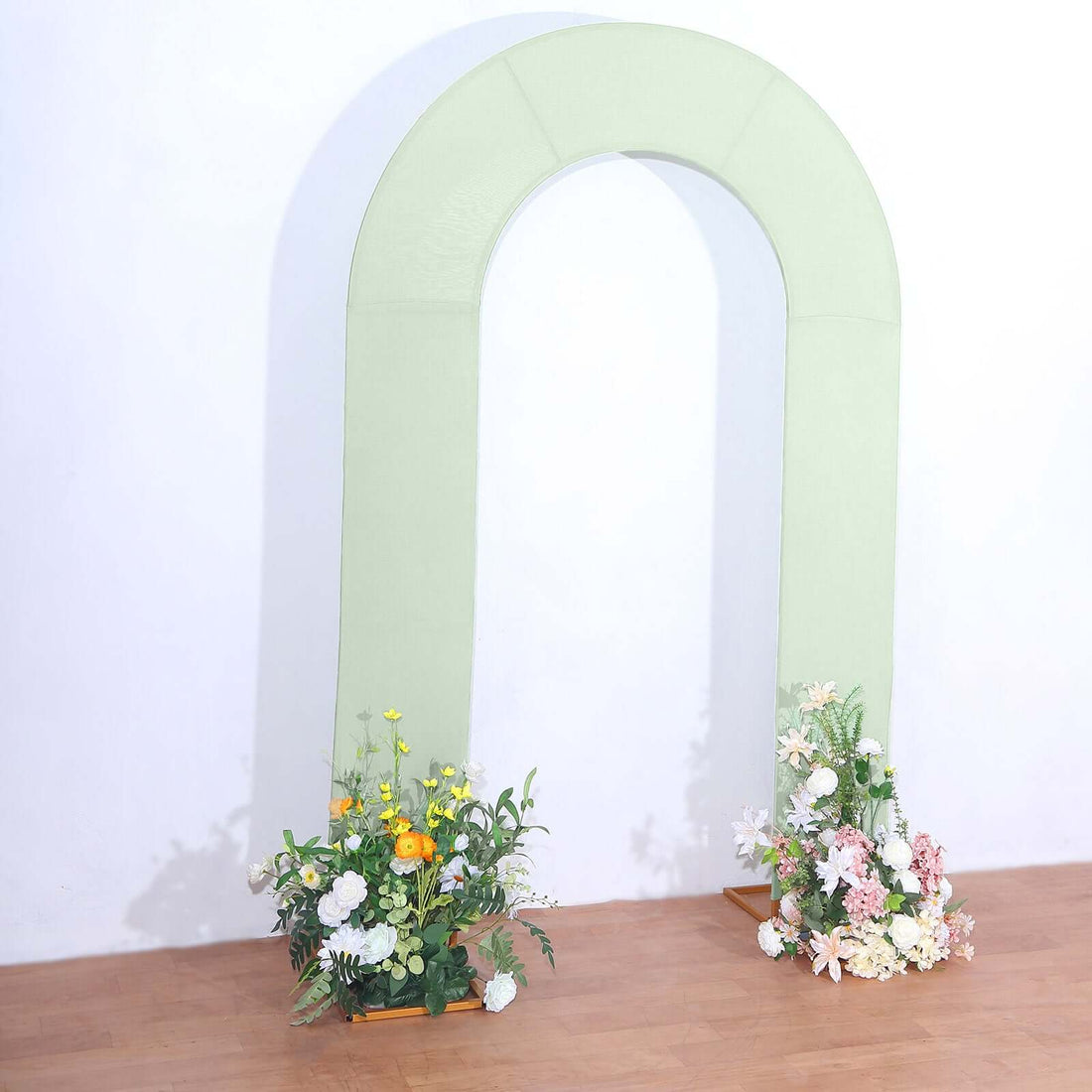 Green arch with floral arrangements at the base against a plain background.