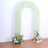 Green arch with floral arrangements at the base against a plain background.