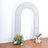 Decorative arch with floral arrangements on the floor.