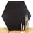 Hexagonal black backdrop with gold support and tall candle holders.