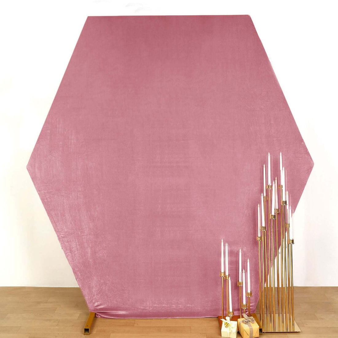 Hexagonal pink backdrop with gold candle holders and candles
