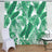 Tropical green leaf backdrop with white chair and table arrangement.