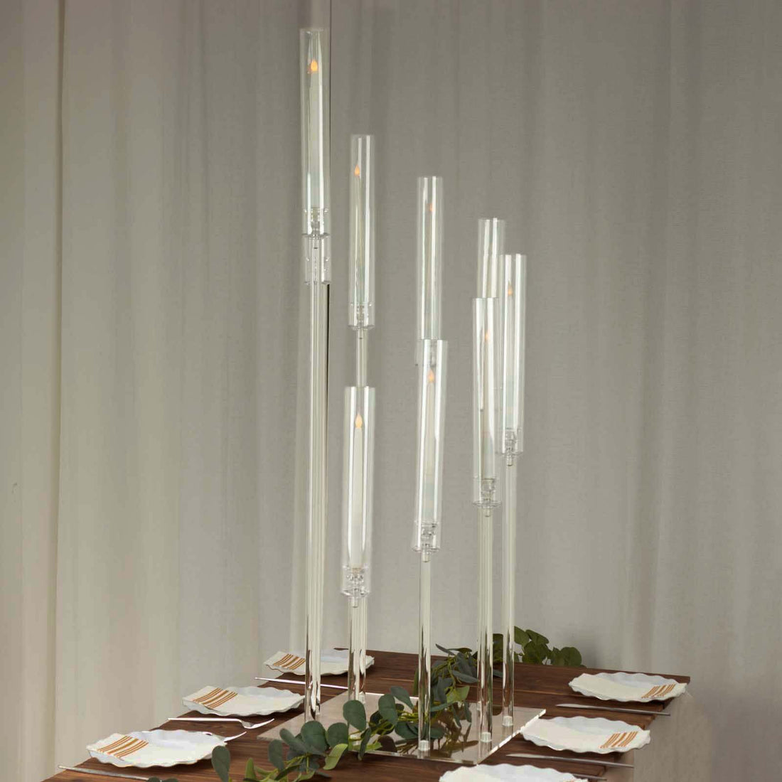 Elegant glass candle holders in various heights for dining table decor.