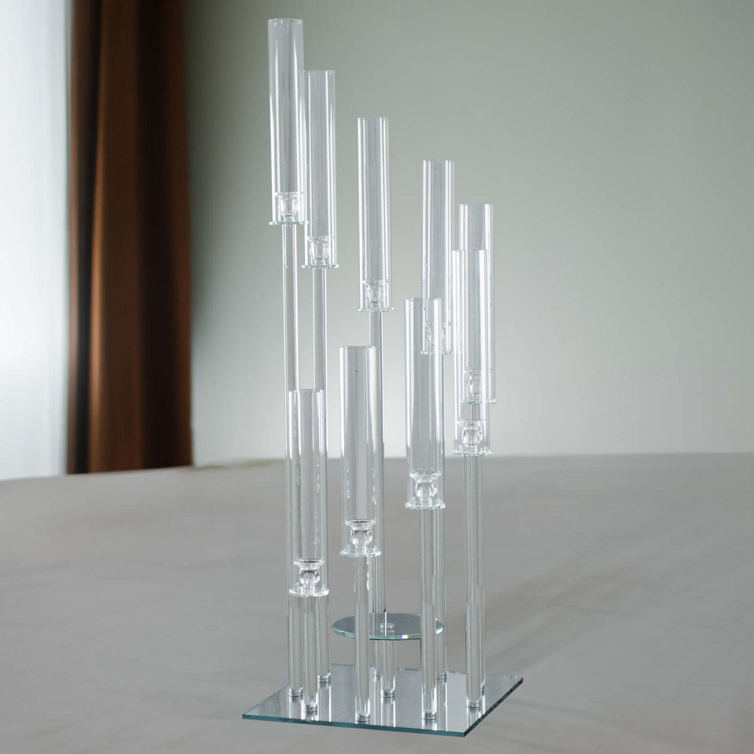 Modern glass sculpture with cylindrical tubes on a mirrored base.