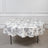 Round floral tablecloth on a table with a neutral backdrop.