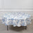 Floral round tablecloth on a round table against a plain backdrop.