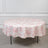 Round floral tablecloth in pink and white on a plain background.