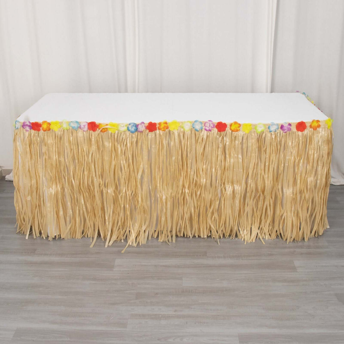 Hawaiian luau table skirt with colorful flowers and straw fringe