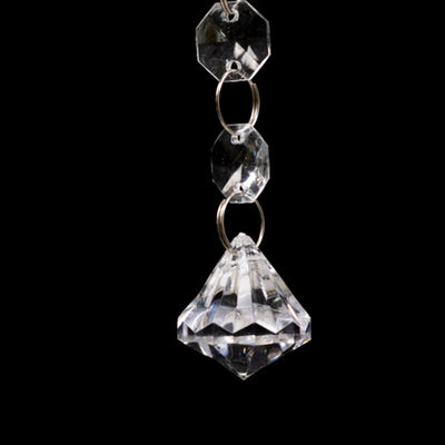 Crystal pendant with geometric design and hanging chain.