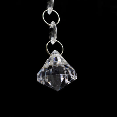 Crystal chandelier pendant with faceted design against a black background.