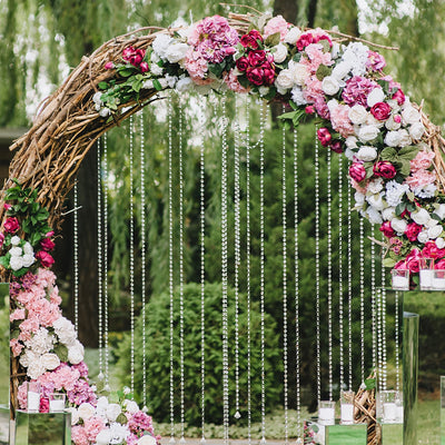 Floral wedding arch with pink and white flowers and hanging crystals.