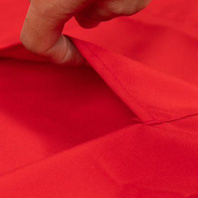 Close-up of fabric texture showing a hand pulling back a red cloth.