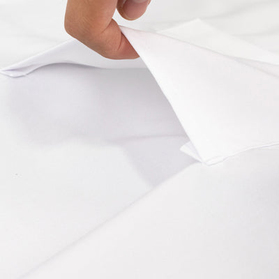 Hand pulling back a layer of soft white fabric.