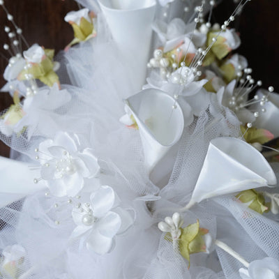 White floral arrangement with lace and pearl accents.