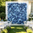 Blue floral wedding backdrop with white chairs and outdoor garden reception tables