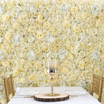 Elegant table setting with gold accents against a floral backdrop of white and yellow roses.