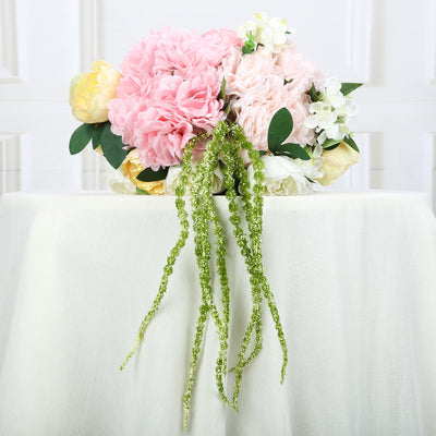 Artificial floral arrangement with pink and white peonies and green accents.