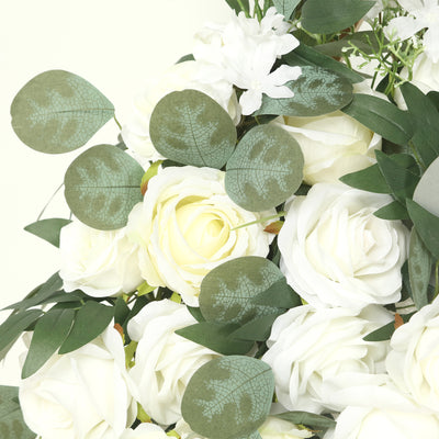 White rose bouquet with green leaves on a light background.