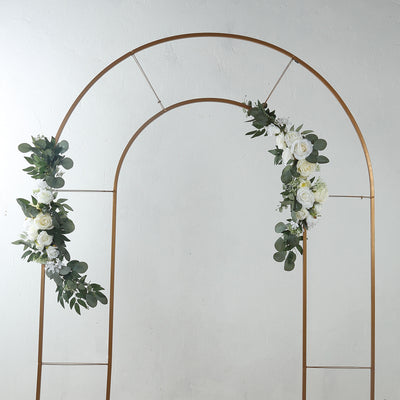 Gold wedding arch with white roses and greenery accents