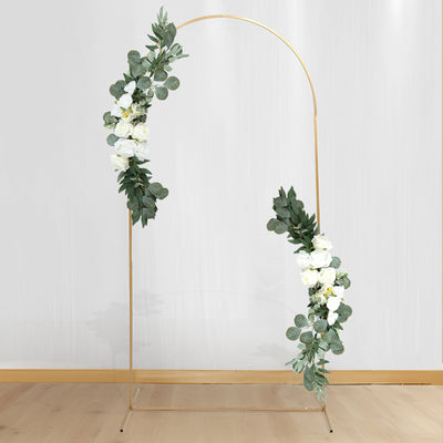 Gold floral arch with white roses and greenery on a plain background