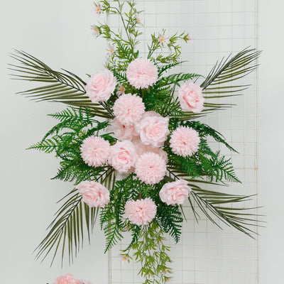 Pink floral arrangement with greenery on a white backdrop.