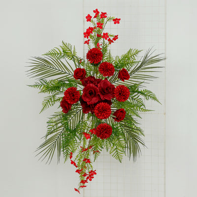 Artificial red floral arrangement with greenery on a white background