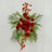 Artificial red floral arrangement with greenery on a white background