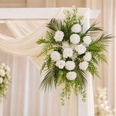 White wedding floral arrangement with roses and greenery on a ceremony arch