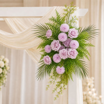 Pink and lavender wedding floral arrangement on white draped arch