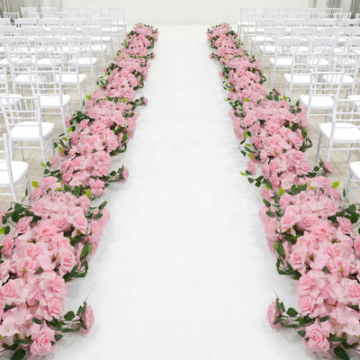 Pink floral wedding aisle with white chairs in an elegant ceremony venue