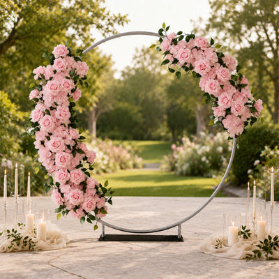 Pink floral wedding arch with candles in an outdoor garden ceremony setting