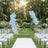 Outdoor wedding ceremony setup with floral arch and white chairs in garden
