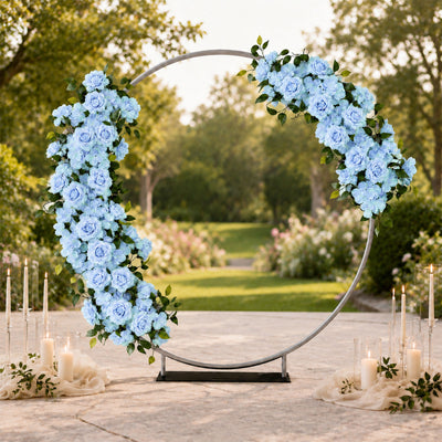 Elegant blue floral wedding arch with candles in an outdoor garden setting