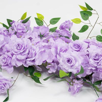Lavender artificial flower garland with green leaves on white background