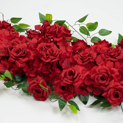 Red roses and green leaves floral arrangement on white background