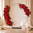 Heart-shaped red rose floral arch with candles for elegant wedding decor