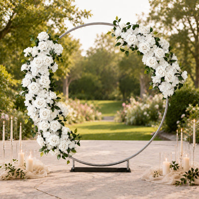 Elegant wedding floral arch with white roses and candles in an outdoor garden setting